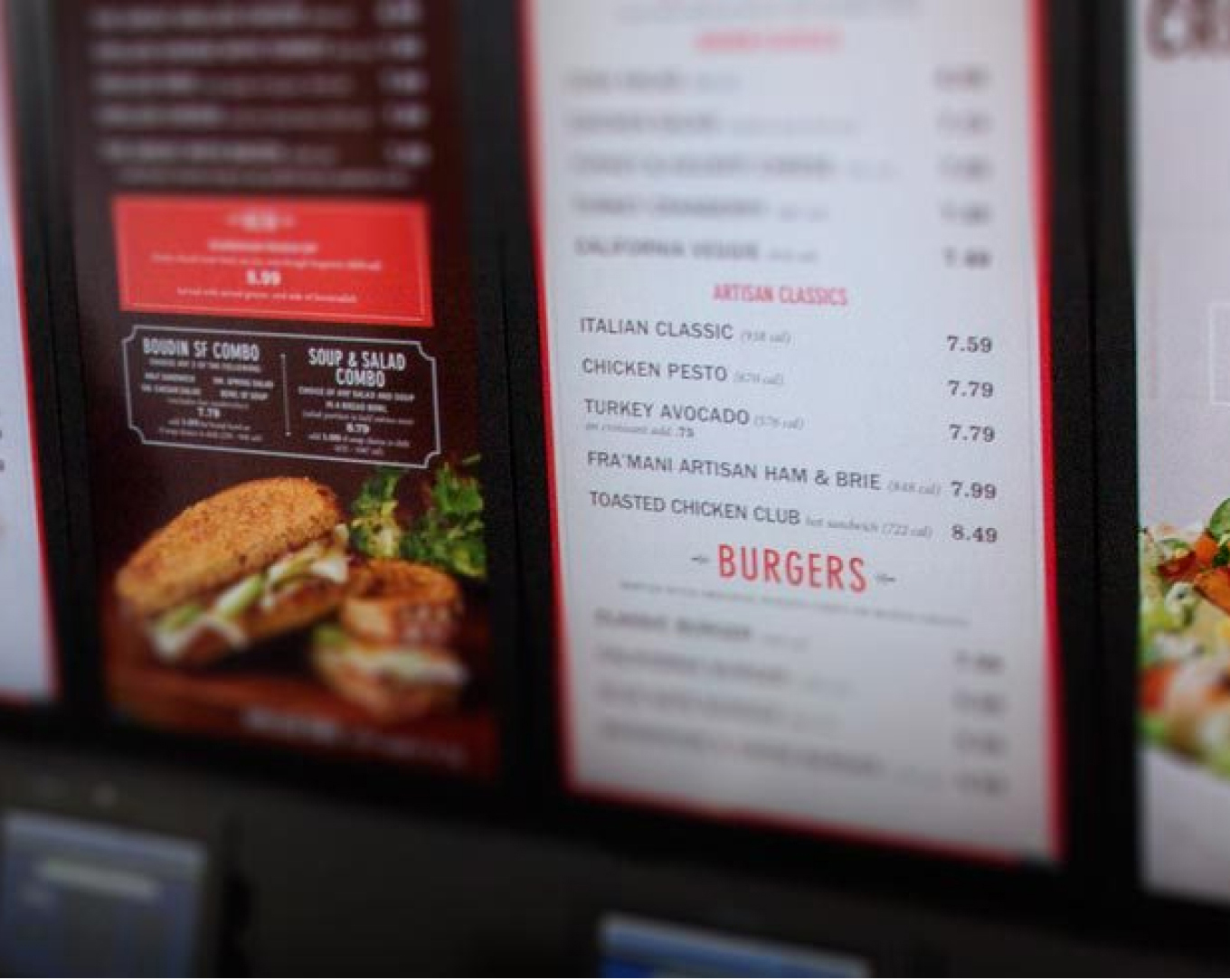 A close-up view of part of a menu board showing sandwiches and burgers. 							